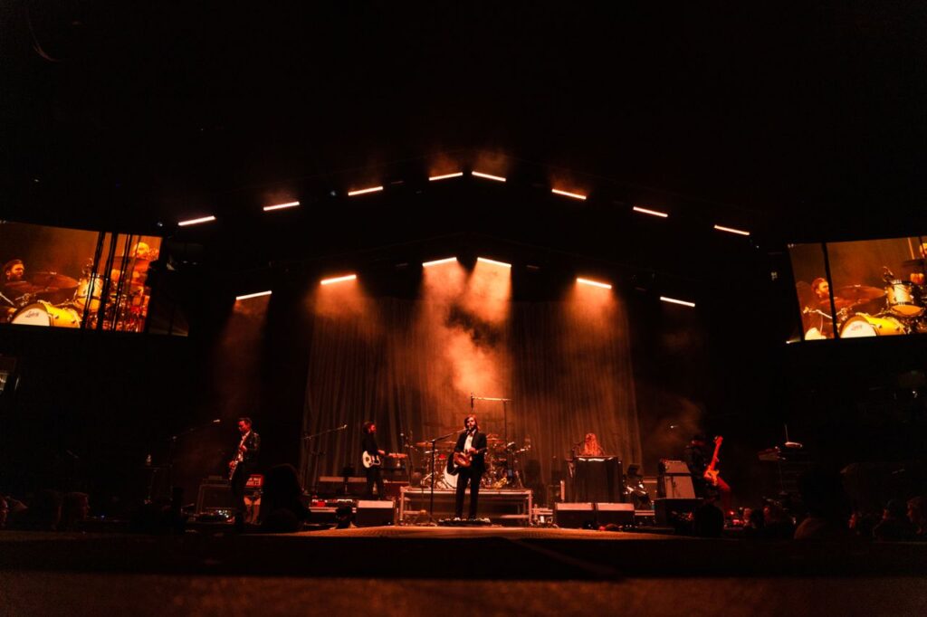 A vibrant live band performance on an illuminated stage at night, capturing the essence of a live music concert.