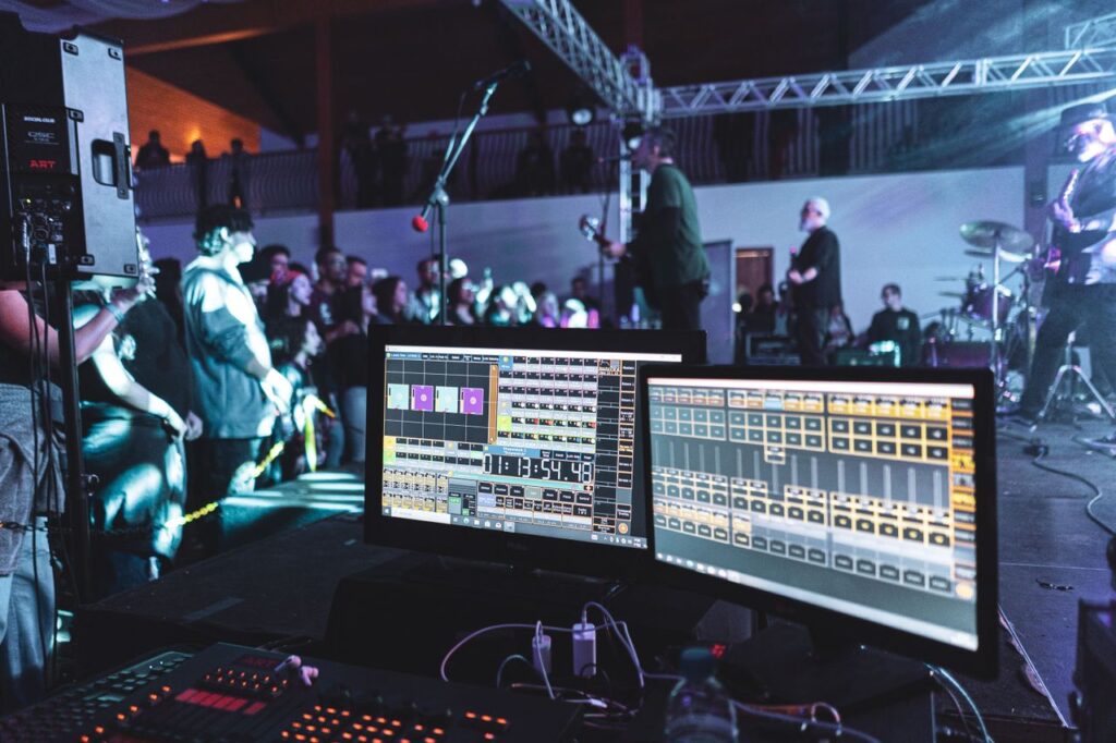 Live concert scene with sound engineering setup and band on stage.
