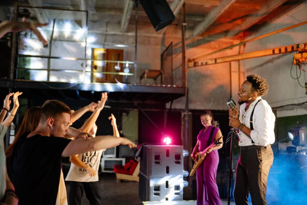 Live band performing in an industrial setting with an excited crowd enjoying the music.